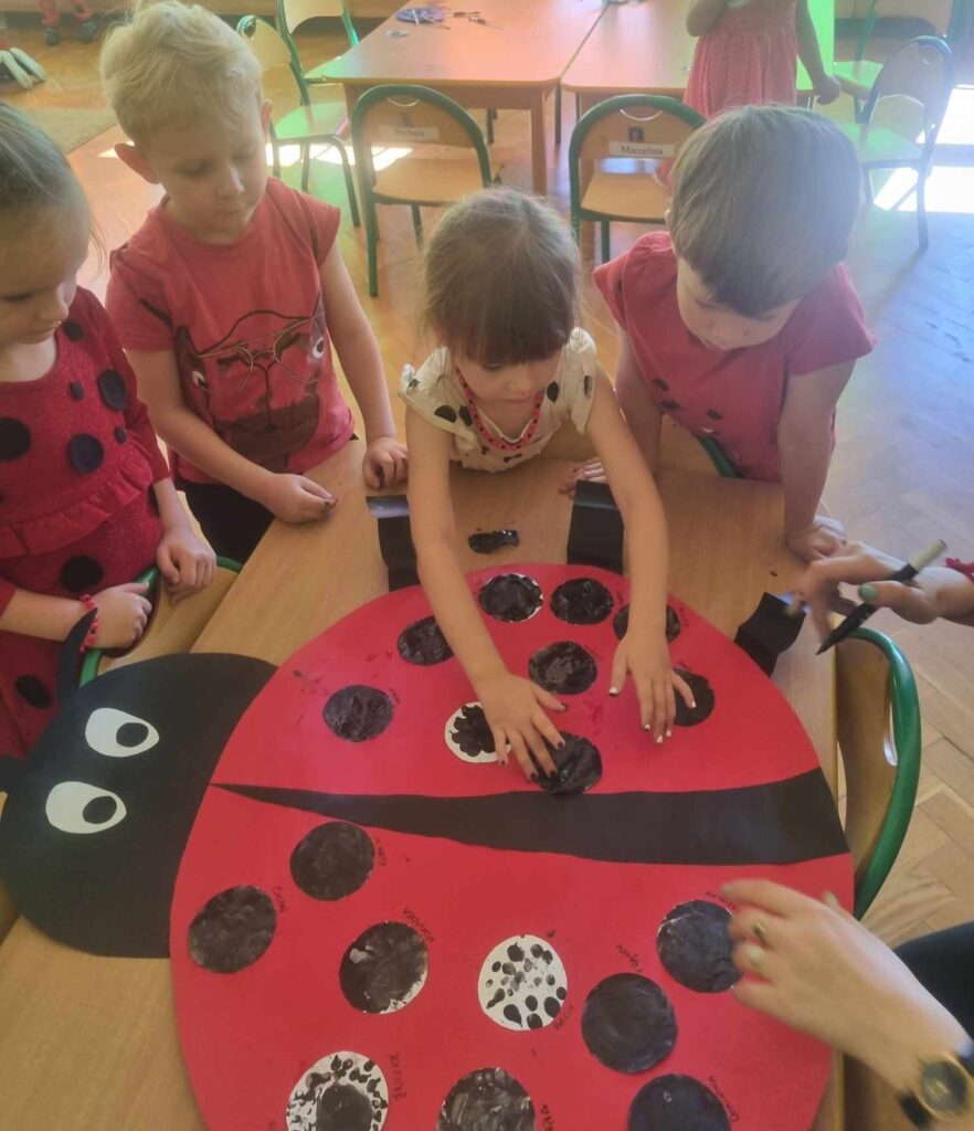 Dzieci tworzą wspólną pracę plastyczną - ,,Biedronka"