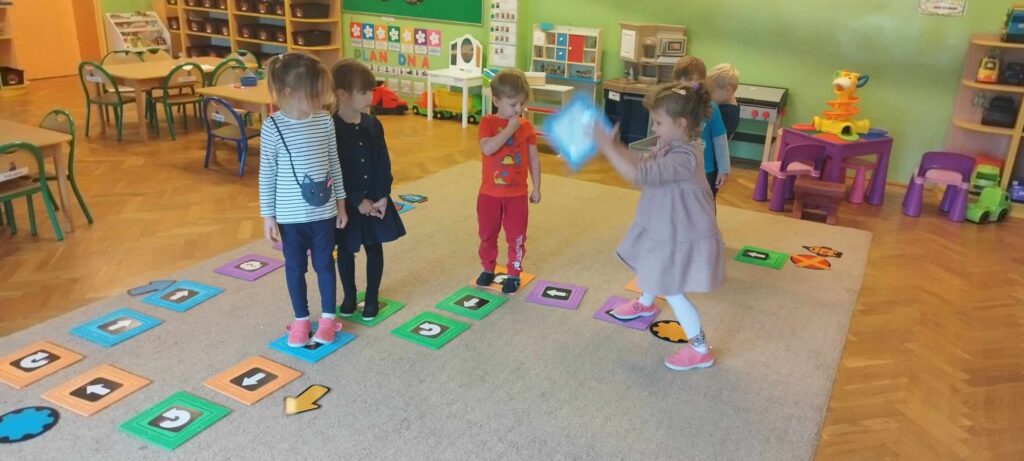 Dzieci grają w grę na dywanie.